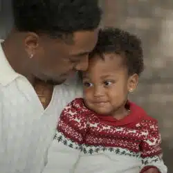 A father affectionately holding his young son, sharing a warm and tender moment.