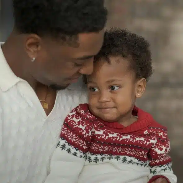 A father affectionately holding his young son, sharing a warm and tender moment.