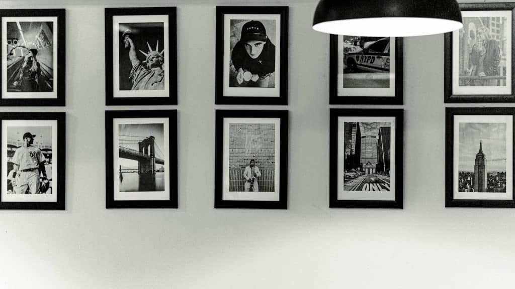 Black and white photos of picture frames displayed on the wall.
