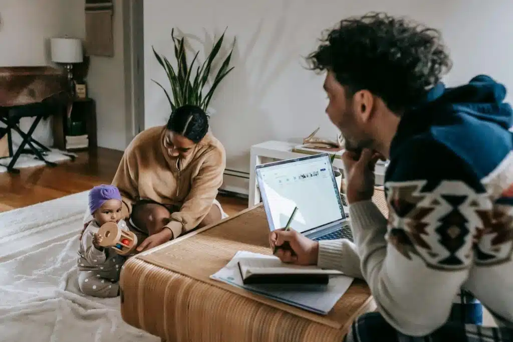 A woman taking care of the baby while a man work 