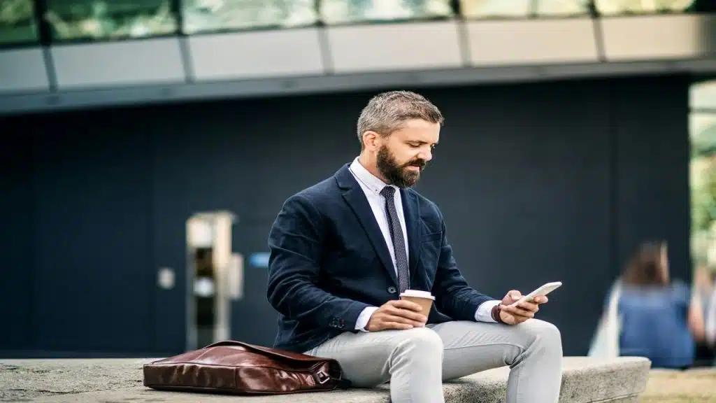 An office worker alone and looking at his phone