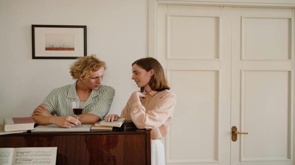 A couple talking by the piano