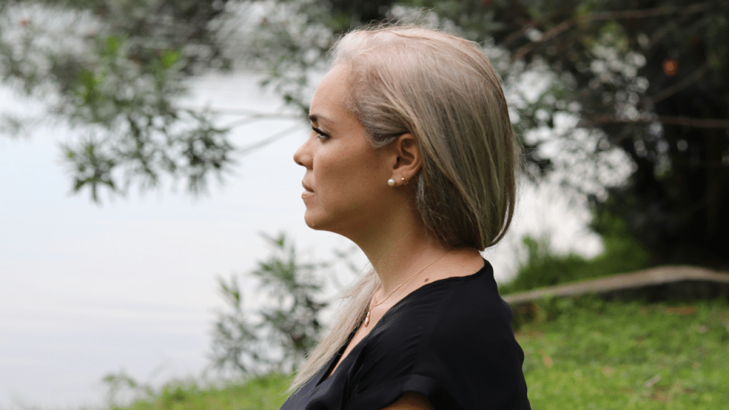 A woman looking upset by a body of water
