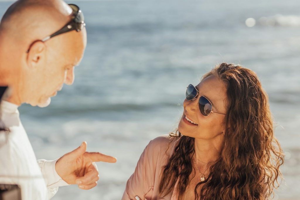 A man and woman talking at the beach.