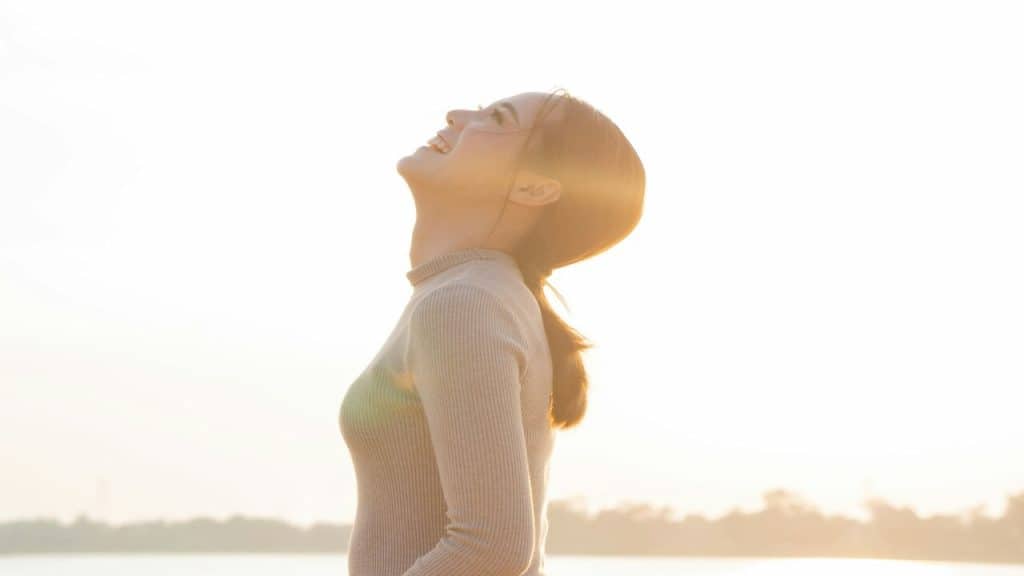 A woman having a deep breath outdoors