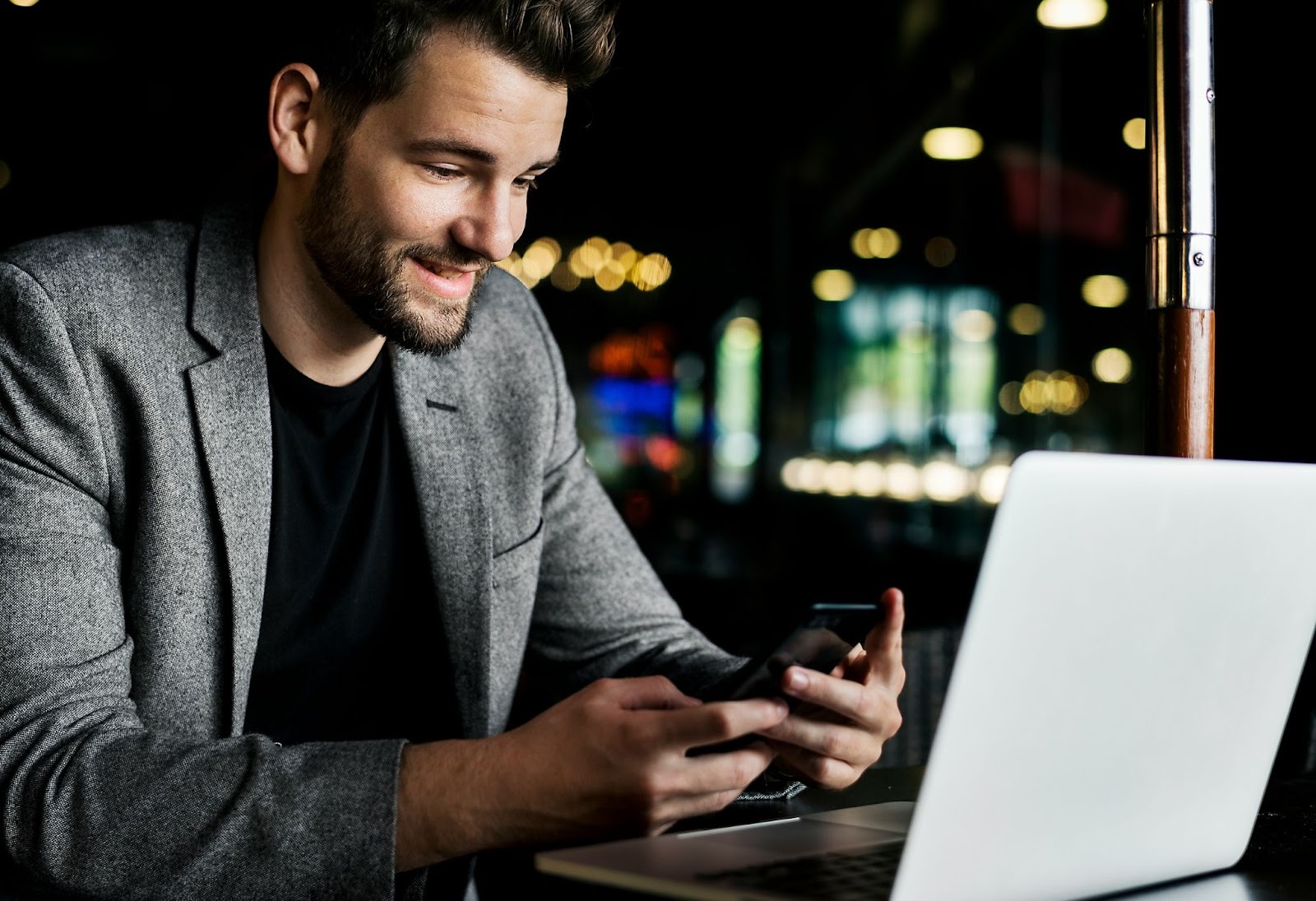A man smiling while using a phone 