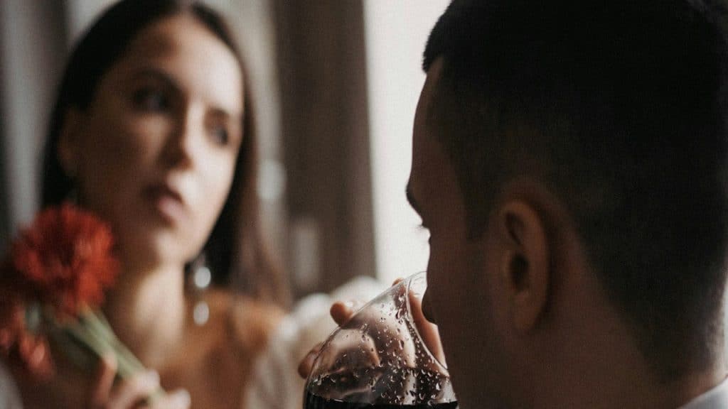 A man and a woman sitting at a table drinking wine.