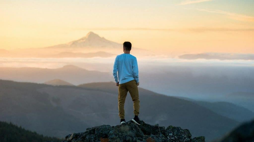 A man standing on the top of a mountain.