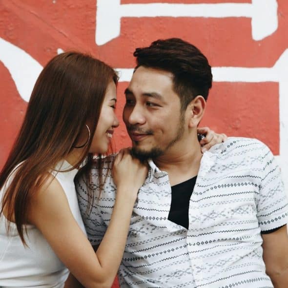 A man and woman looking in each other's eyes while they are sitting together.