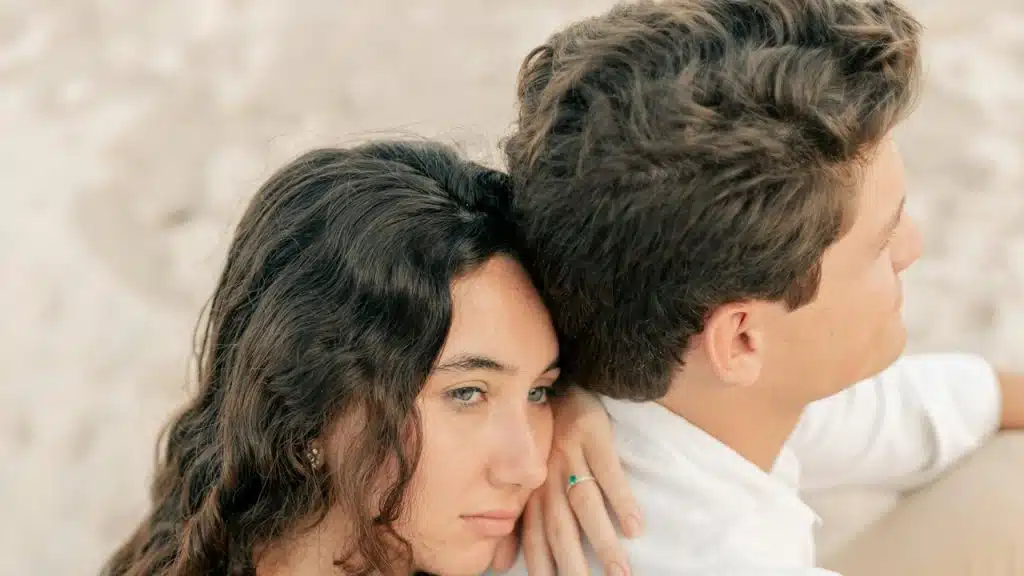 A woman resting her head on a man’s back.