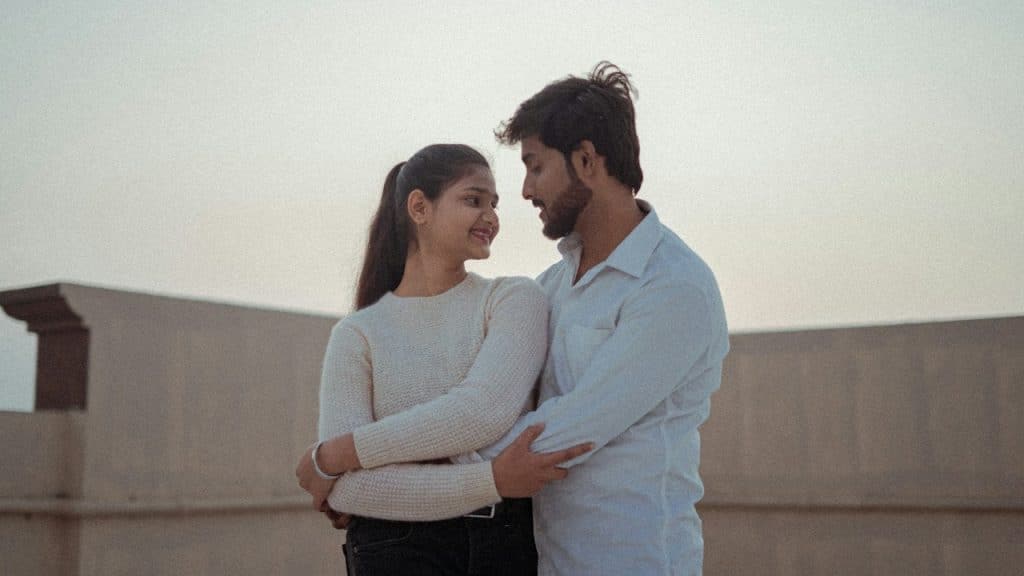 A couple standing close together and looking into each other’s eyes. 