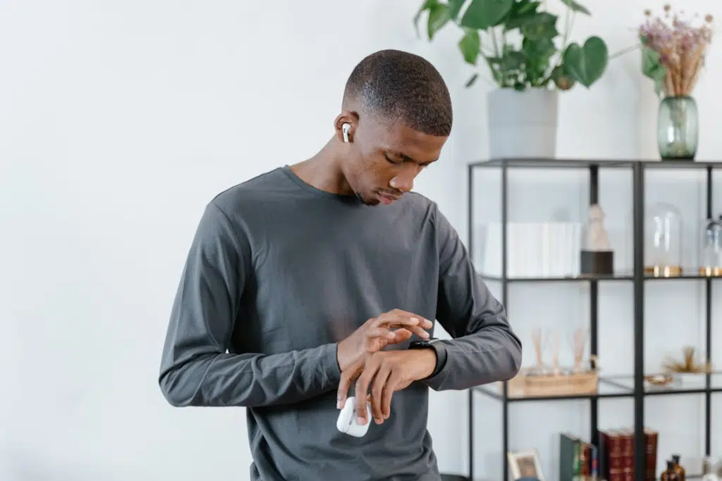 A man  in a gray sweater using his smartwatch