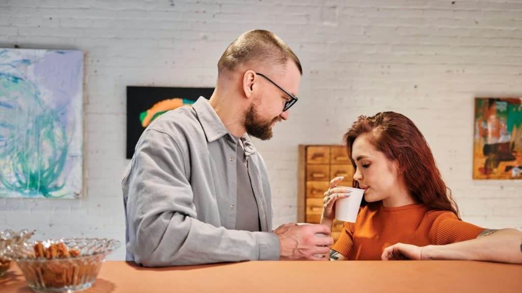 A man standing next to a woman holding a cup.