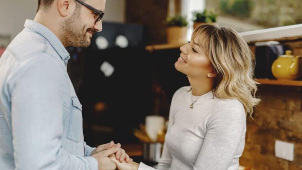 Man gazing at woman with exaggerated admiration while she looks uncomfortable