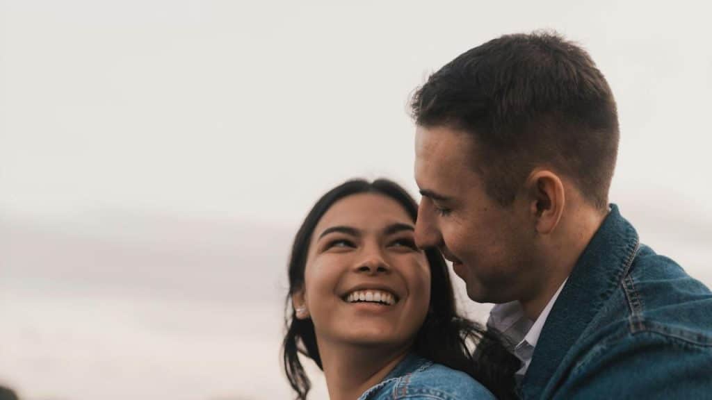 A smiling couple sharing a close moment outdoors.
