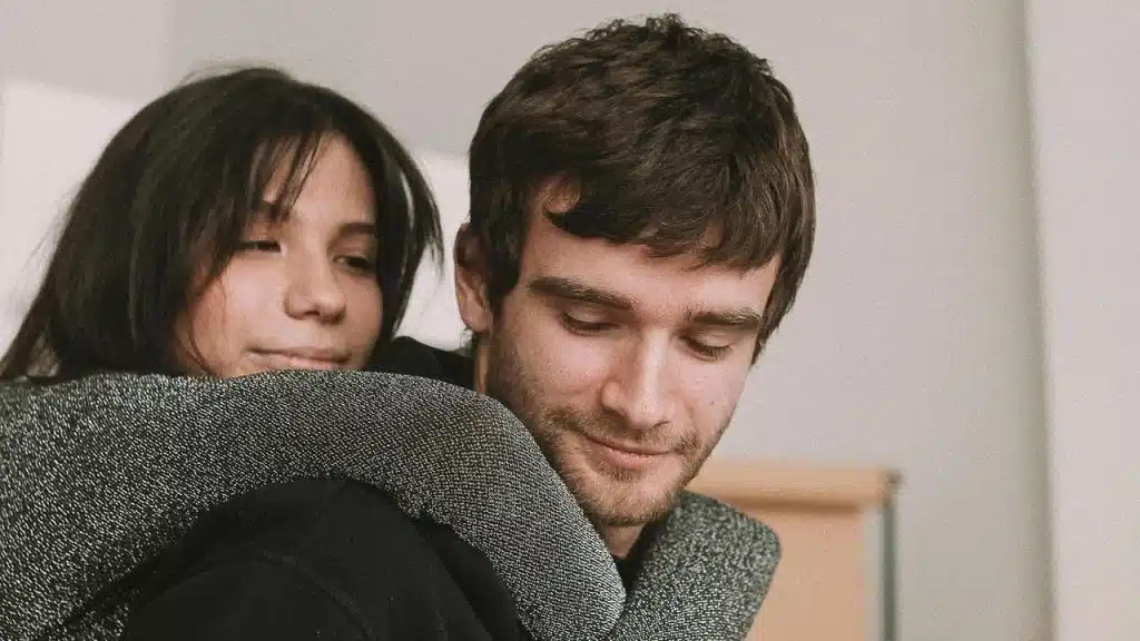 A woman hugging a man from behind.
