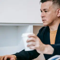 A sad man using a laptop