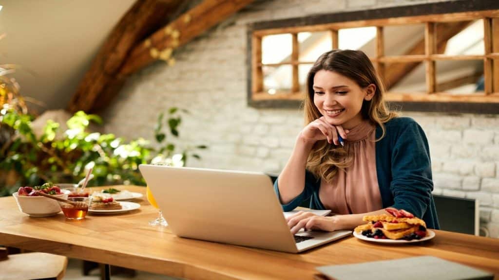 A woman smiling while using her laptop