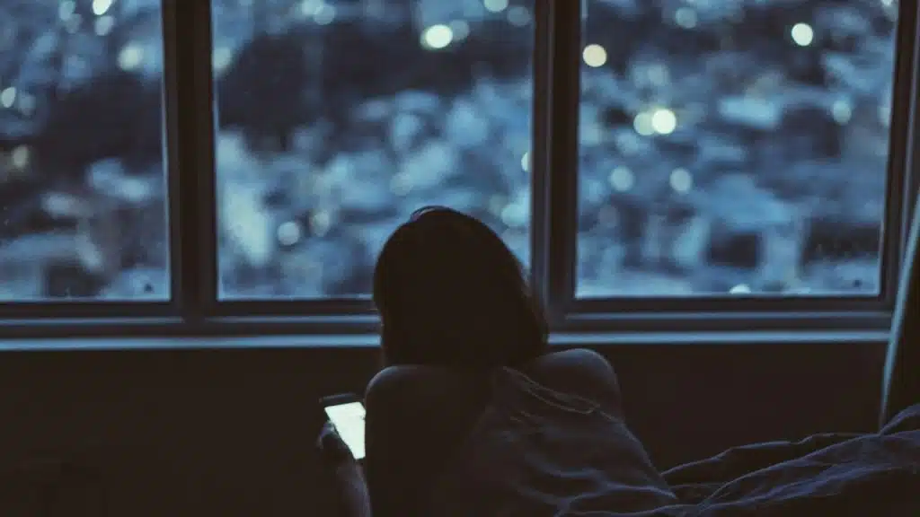 A woman texting in the dark