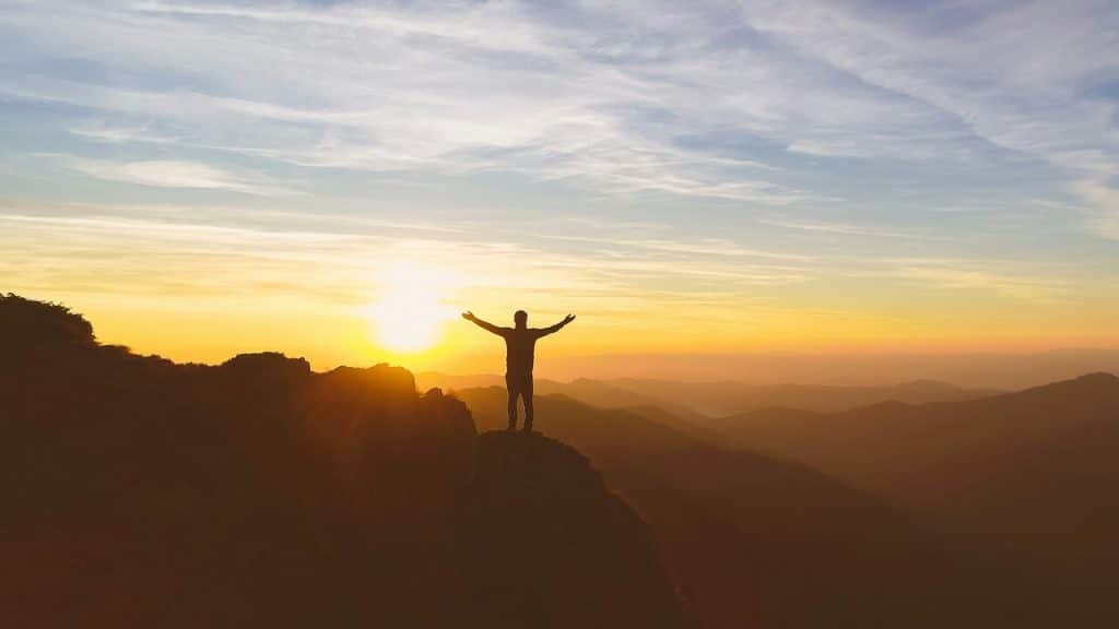 A man with his hands raised to the sky