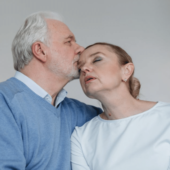 A man kissing his upset wife on the temple