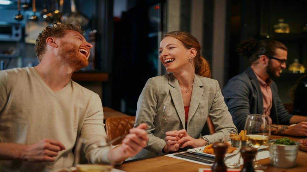 Colleagues laughing while having a meal