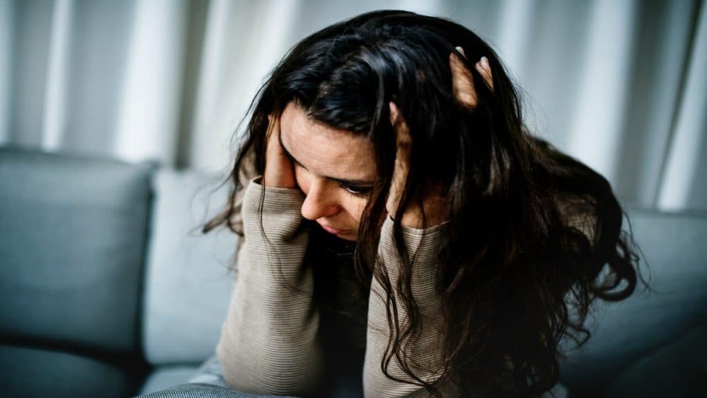A woman looking anxious at home