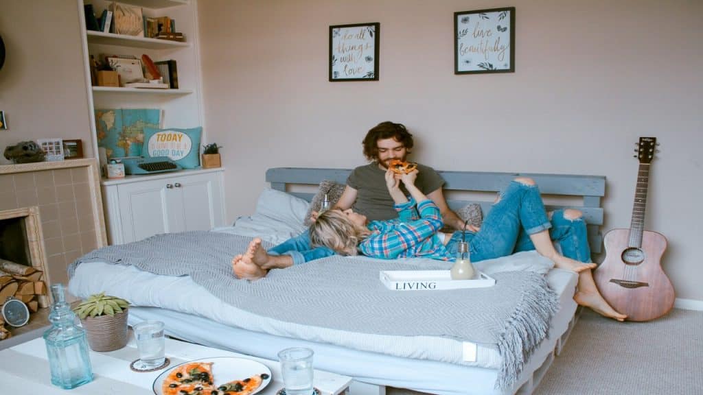 A couple eating in bed.