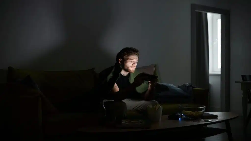 A man playing phone games in the dark