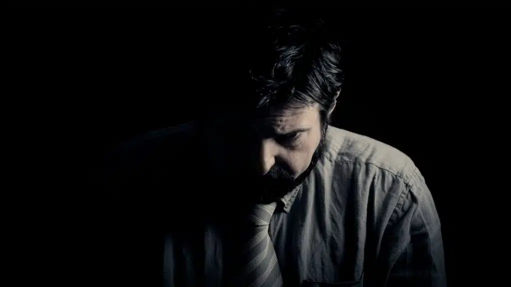 A man looking sad in the dark