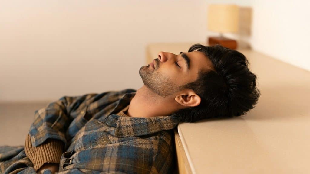 A man laying with his eyes closed