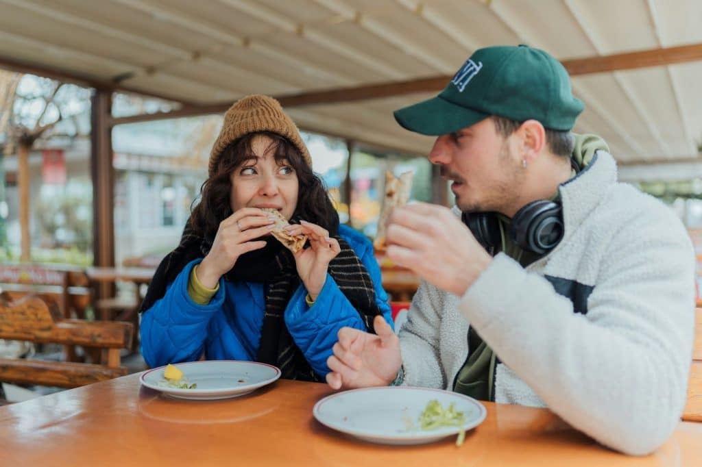 A man and woman eating while looking at each other