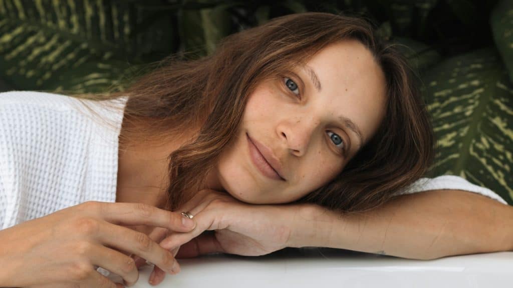 A woman resting her head on her arm while she sits at a table.
