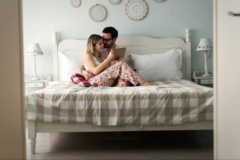 A man and woman at the bed