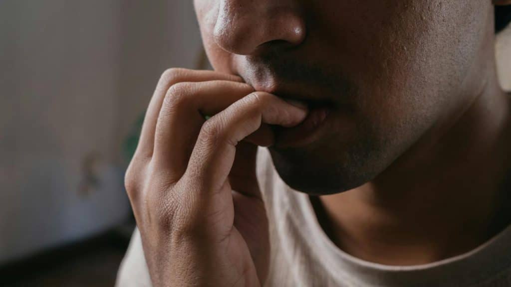A close-up of someone biting their fingernail.