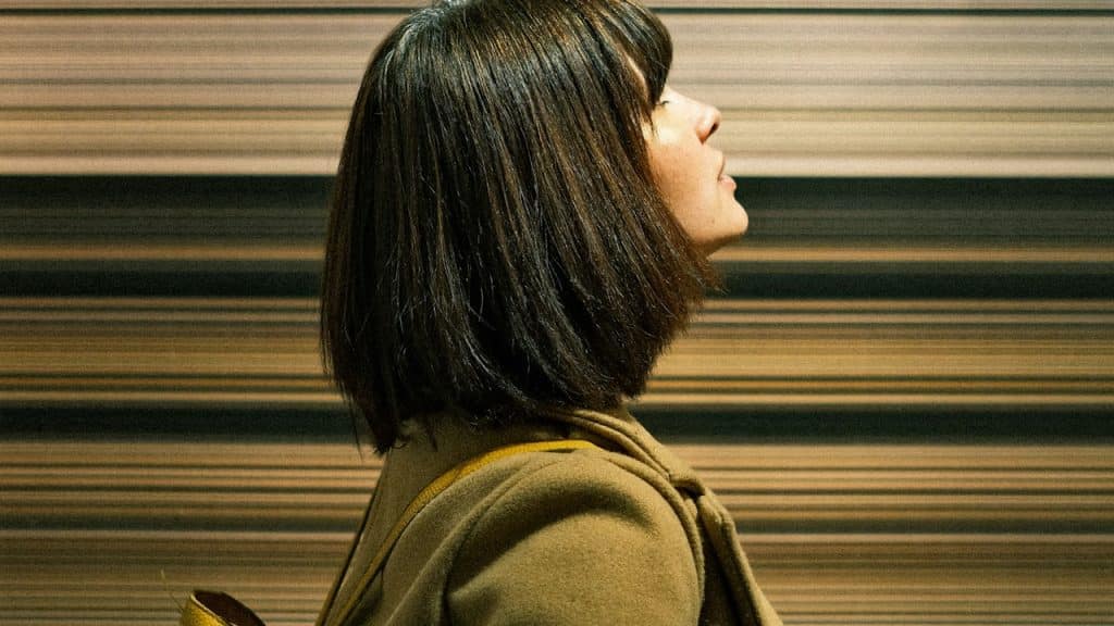 A woman with a bob cut looking upwards.