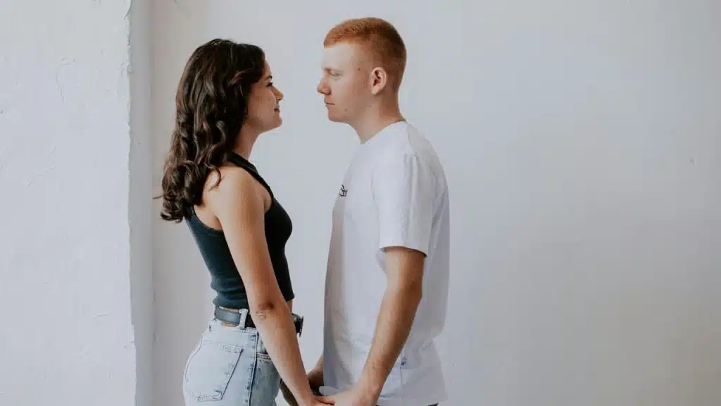 A couple standing close to each other and gazing into each other’s eyes.