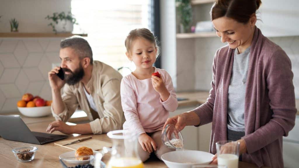 A family preparing breakfast together in a kitchen.