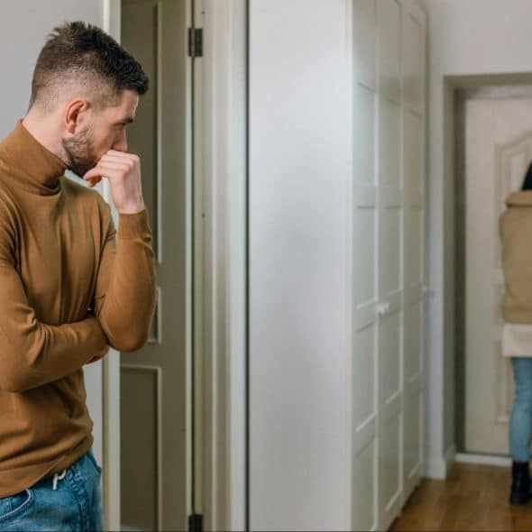 A man looking at the woman walking out