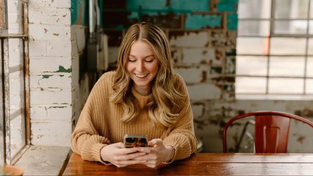 A woman using a phone to text a man