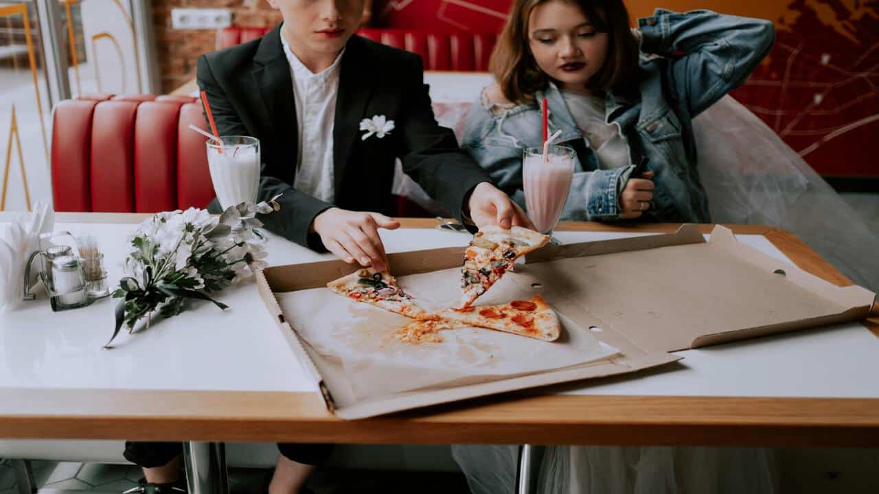A couple looking bored during their pizza date