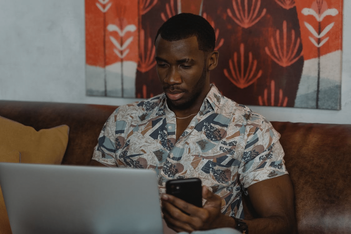 A man using his phone and laptop