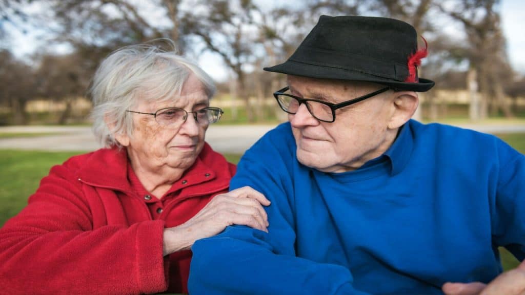 An older couple sitting and looking serious