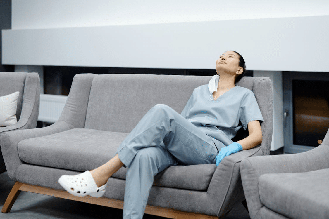 A tired nurse reclining on the couch