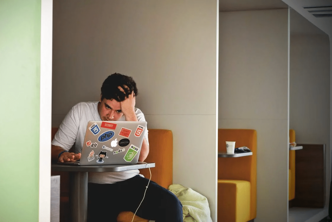 A frustrated man looking at the laptop