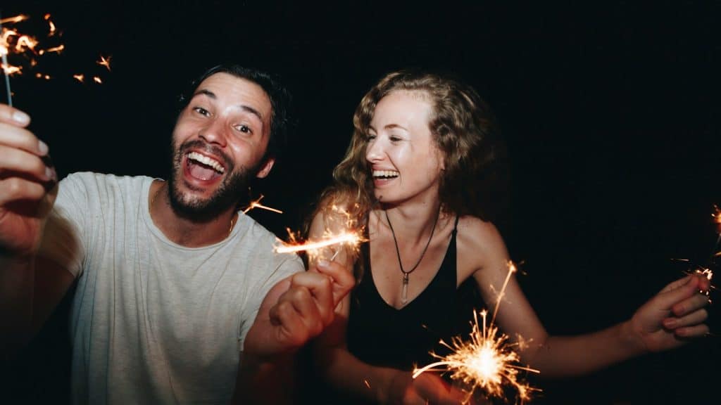 A happy couple lighting the sparklers.