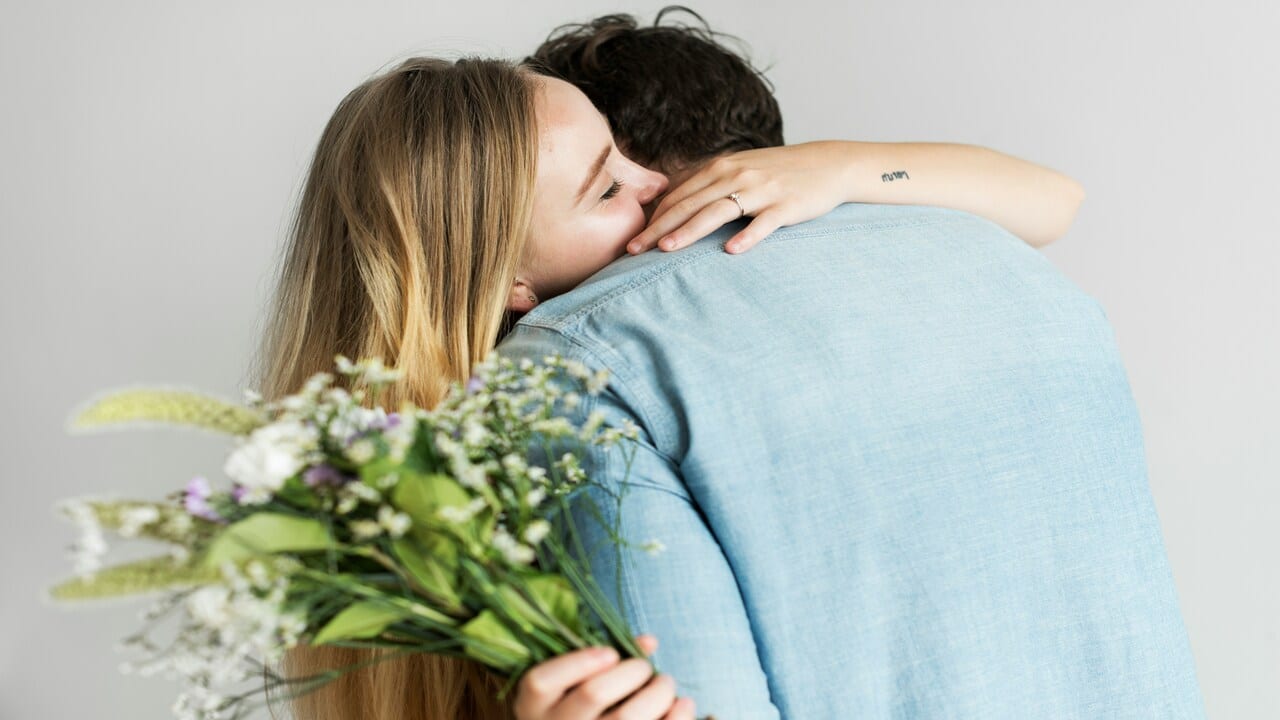 A man surprising his wife with a bouquet