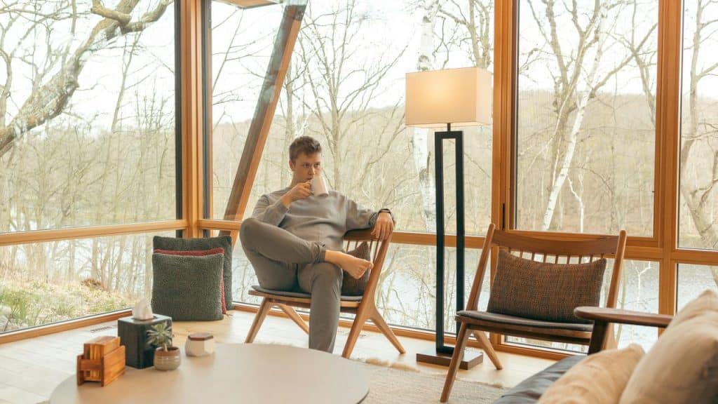 A man drinking from a mug indoors, enjoying the view.
