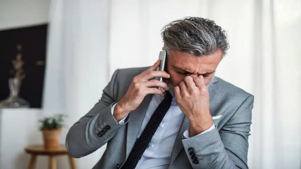 A man looking frustrated while on the phone