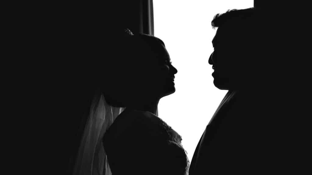 A silhouette of a couple looking at each other and smiling.